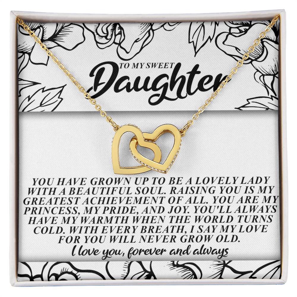 The Daughter-Beautiful Soul - Interlocking Hearts Necklace features intertwined gold hearts on an 18k yellow gold finish chain, displayed in a box reading "To my sweet daughter." Inside is a heartfelt message about love and pride against an elegant black and white floral background.