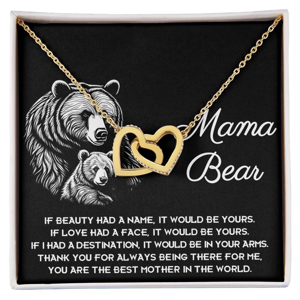 The "To Mom, In Your Arms - Interlocking Hearts Necklace" showcases a gold heart design on a black backdrop with a cute bear illustration and "Mama Bear" text, adorned with cubic zirconia crystals and paired with a heartfelt message. Ideal for personalized gifting to someone special.