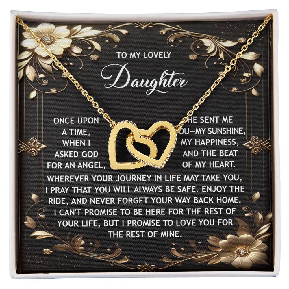 The "Daughter-Be Safe - Interlocking Hearts Necklace," adorned with cubic zirconia crystals, is elegantly presented on a black and gold card featuring a heartfelt message for a daughter.