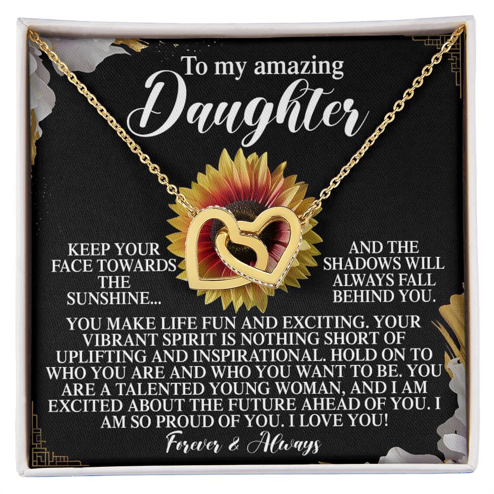The Daughter-Vibrant Spirit - Interlocking Hearts Necklace, made of surgical steel with cubic zirconia, is presented on a card stating: "To my amazing Daughter. Keep your face towards the sunshine... Forever & Always," set against a sunflower design backdrop.