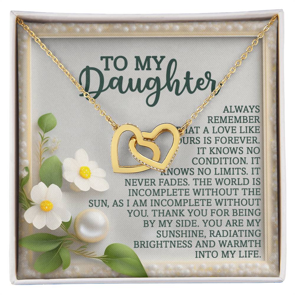 The Daughter-Love Forever - Interlocking Hearts Necklace, with a rose gold finish and cubic zirconia crystals, is displayed in a box featuring white flowers, pearls, and a heartfelt message to a daughter.