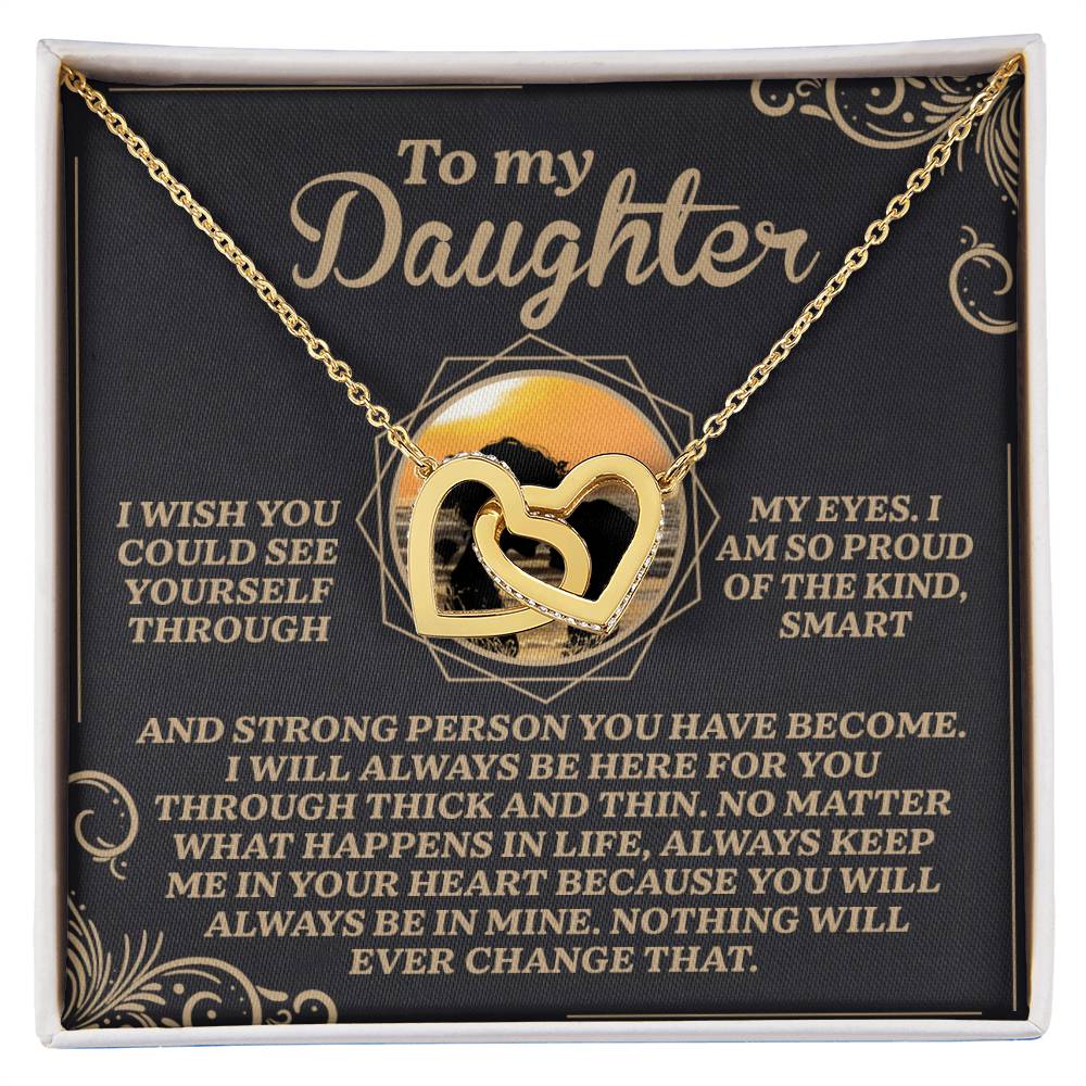 The Daughter-Proud Heart Interlocking Hearts necklace, with a rose gold finish and cubic zirconia crystals, is elegantly showcased in a gift box. A heartfelt message from a parent to their daughter, expressing pride, love, and support, is displayed in elegant gold lettering as the background.