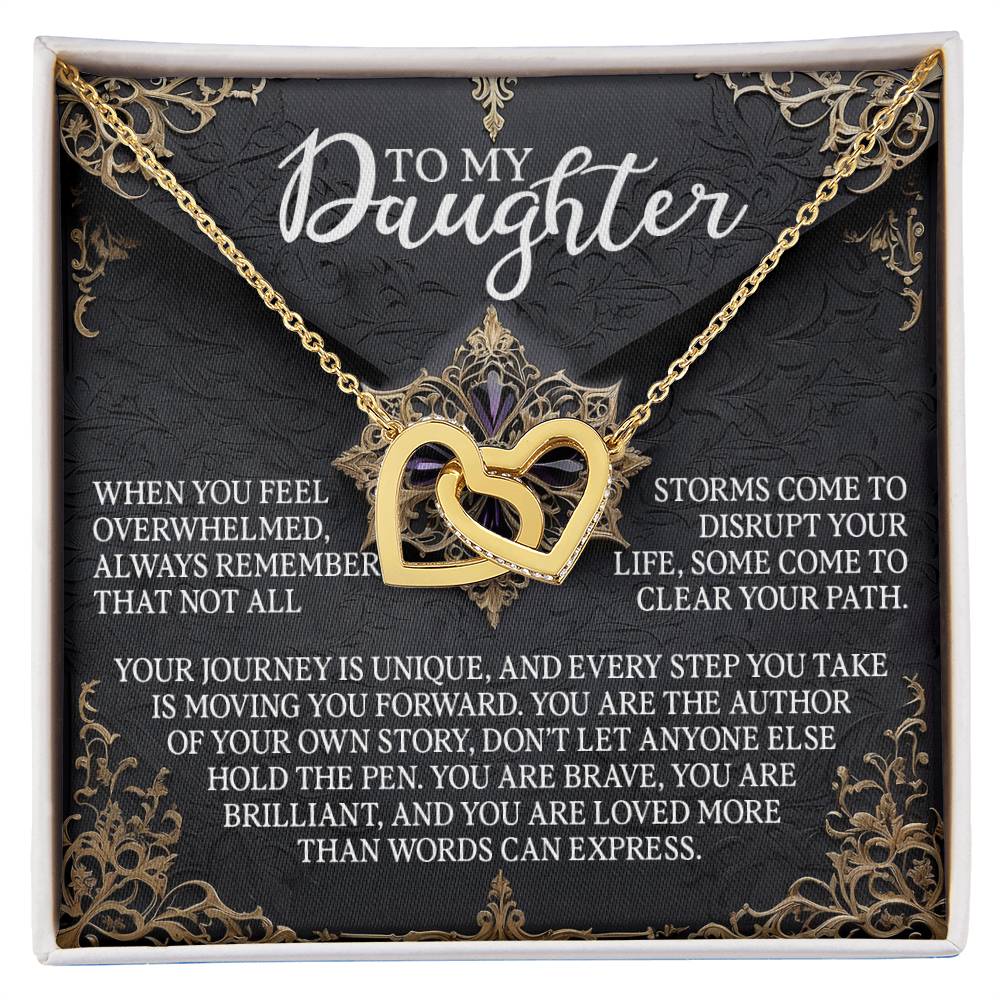 The Daughter-The Pen - Interlocking Hearts Necklace features heart pendants with cubic zirconia crystals against a black and gold background. The message reads, "To My Daughter," offering words of resilience and love.