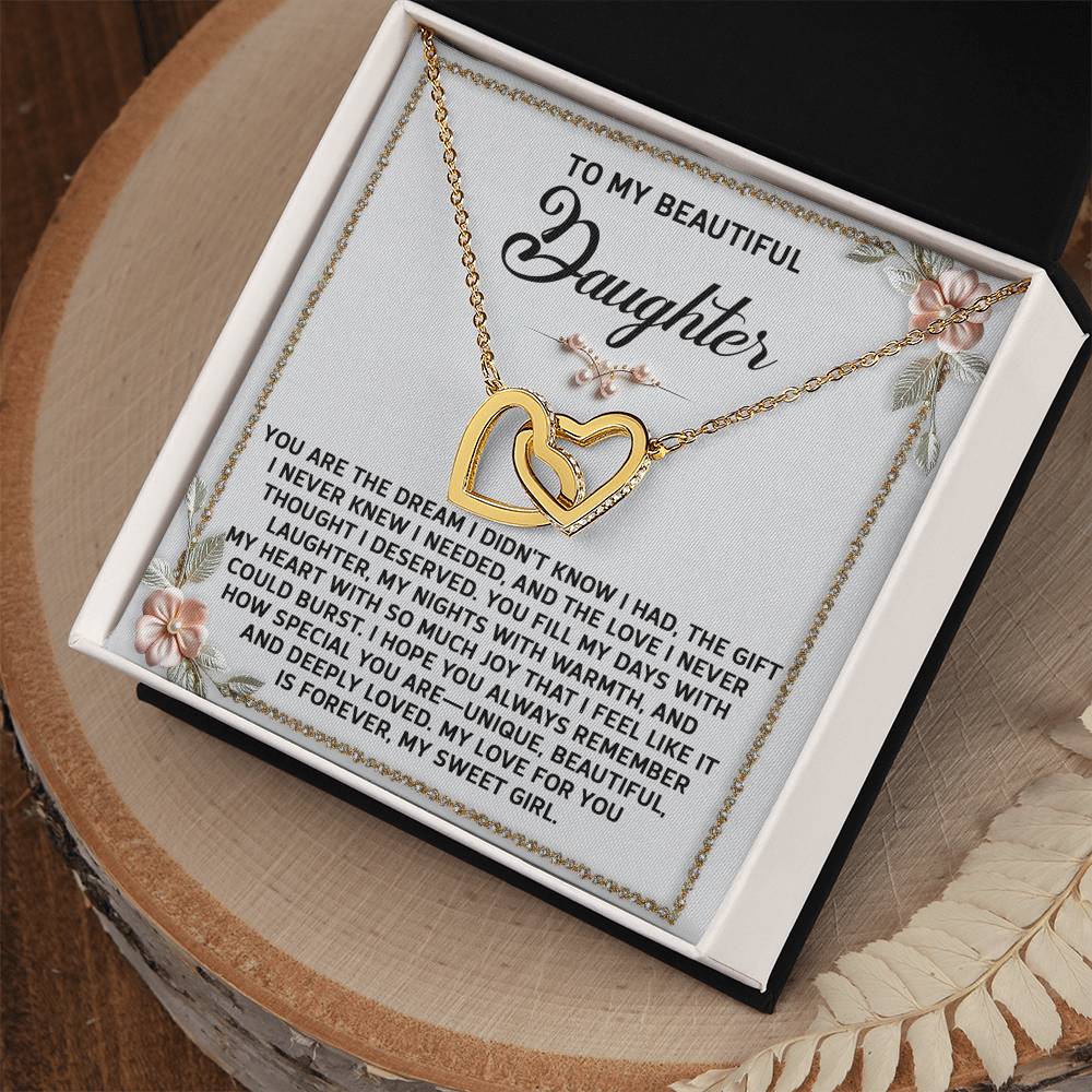 The Daughter-My Sweet Girl - Interlocking Hearts Necklace features shimmering cubic zirconia and a rose gold finish. It comes in an elegant gift box with a message expressing love and appreciation for a daughter.