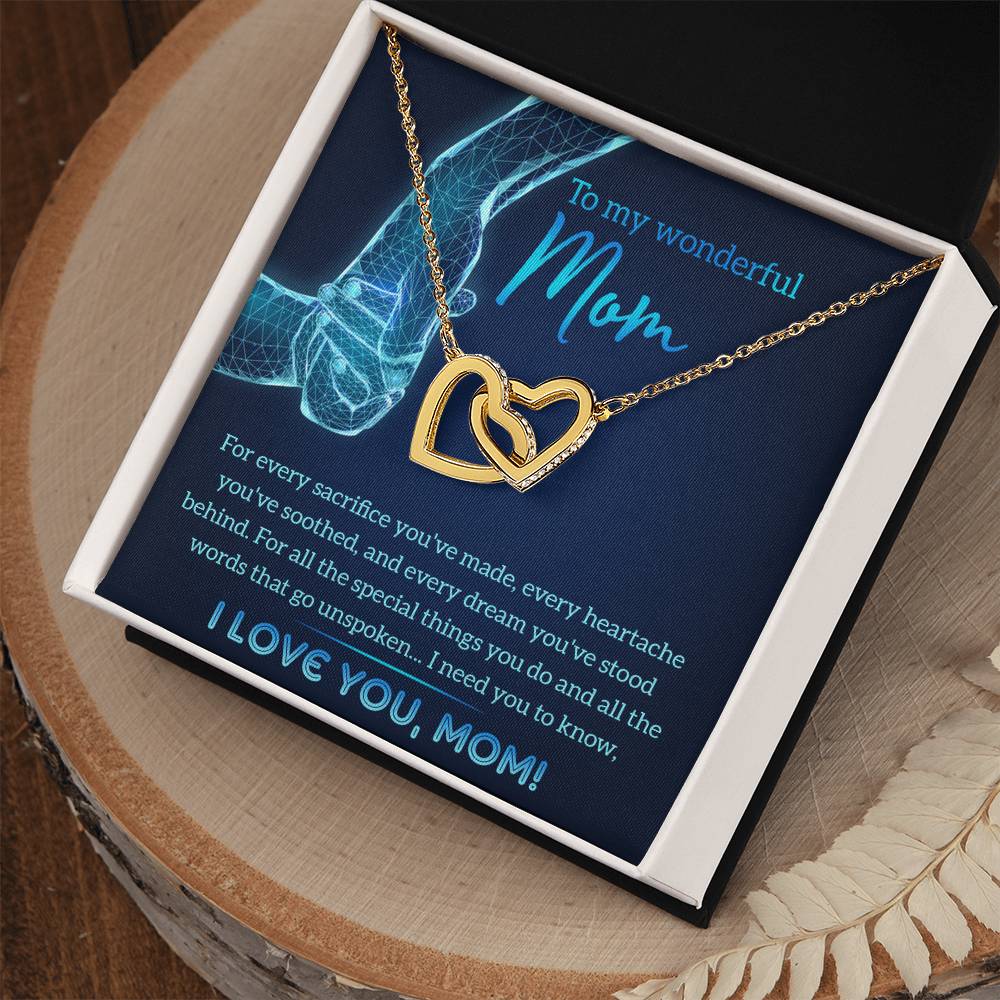 A "To Mom, Stood Behind" box with an interlocking hearts necklace featuring cubic zirconia crystals is presented on a card with a heartfelt message to a mother.