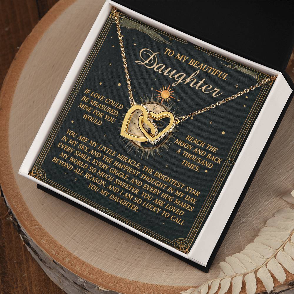 The "Daughter-To Call You - Interlocking Hearts Necklace" with a cubic zirconia design comes in an open box, accompanied by a heartfelt "To My Beautiful Daughter" card. The elegant dark green background with gold and white text enhances its charm.