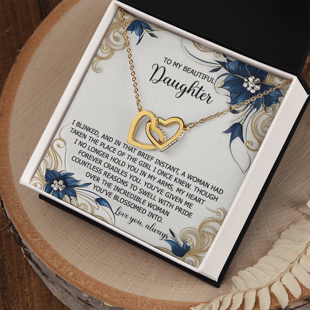 The Daughter-In My Arms - Interlocking Hearts Necklace features a rose gold finish with heart pendants, elegantly displayed on a floral card inscribed: "To my beautiful daughter," alongside a touching message about time and love, highlighted with shimmering cubic zirconia crystals.