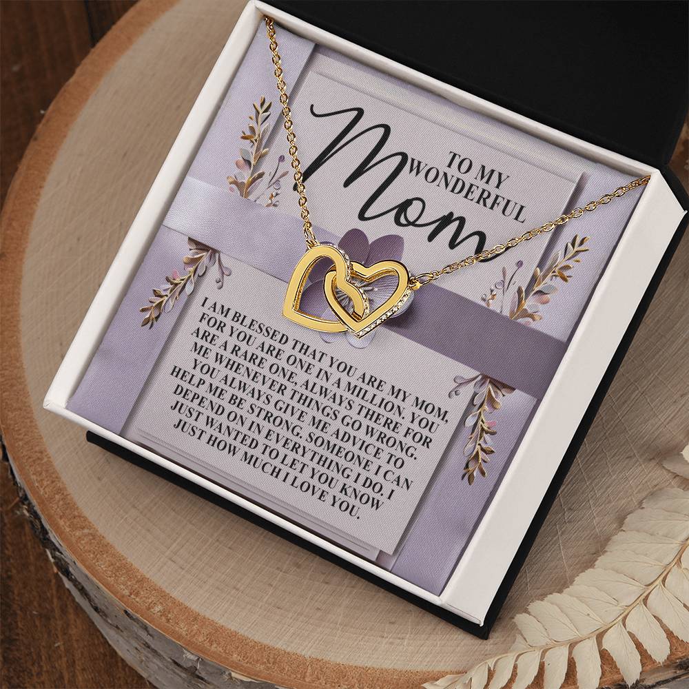 The Mom-Rare One Interlocking Hearts Necklace in rose gold, adorned with cubic zirconia, is showcased in a black jewelry box on a floral card with a purple ribbon and a message of love and gratitude for a "wonderful mom.
