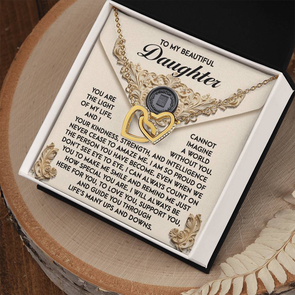 The Daughter-Amaze Me - Interlocking Hearts Necklace, with its gold heart shape and shimmering cubic zirconia crystals, conveys a heartfelt message to a daughter. It comes in an ornate box, symbolizing love and pride.