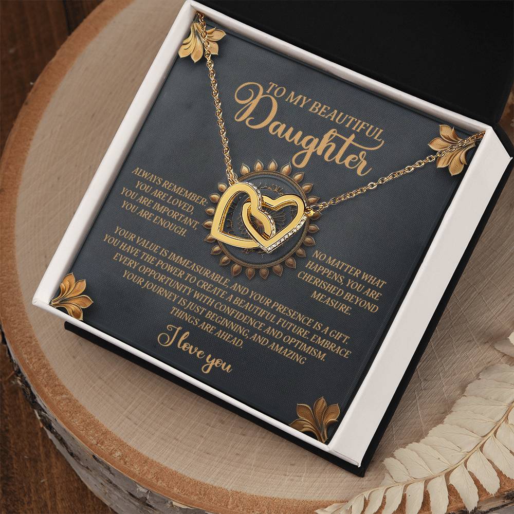 The Daughter-Beautiful Future - Interlocking Hearts Necklace is presented on a card reading, "To my beautiful daughter," with a heartfelt message about her importance. The gold necklace showcases two intertwined hearts adorned with cubic zirconia crystals, sparkling with love, and comes in a black box.