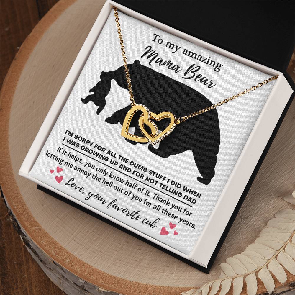 The "To Mom, Not Telling Dad - Interlocking Hearts Necklace" features cubic zirconia crystals and comes in a box with a heartfelt message for "Mama Bear" from "your favorite cub," expressing love and apologies.