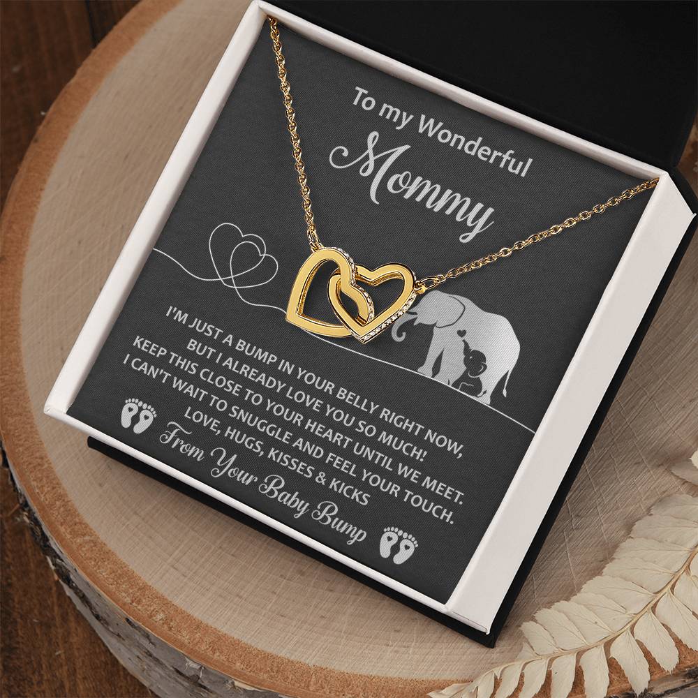 This unique gift, the "To Mama To Be, Until We Meet - Interlocking Hearts Necklace," features cubic zirconia crystals and is displayed on a card with a touching message from an unborn child to "Mommy," alongside a charming adult and baby elephant illustration.