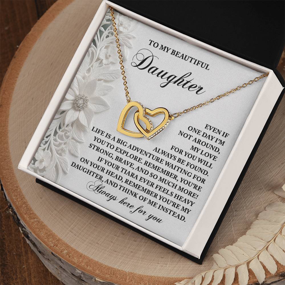 The Daughter-Think Of Me Interlocking Hearts Necklace, adorned with cubic zirconia and an 18k yellow gold finish, is presented in a black box. It includes a heartfelt message card for your daughter.
