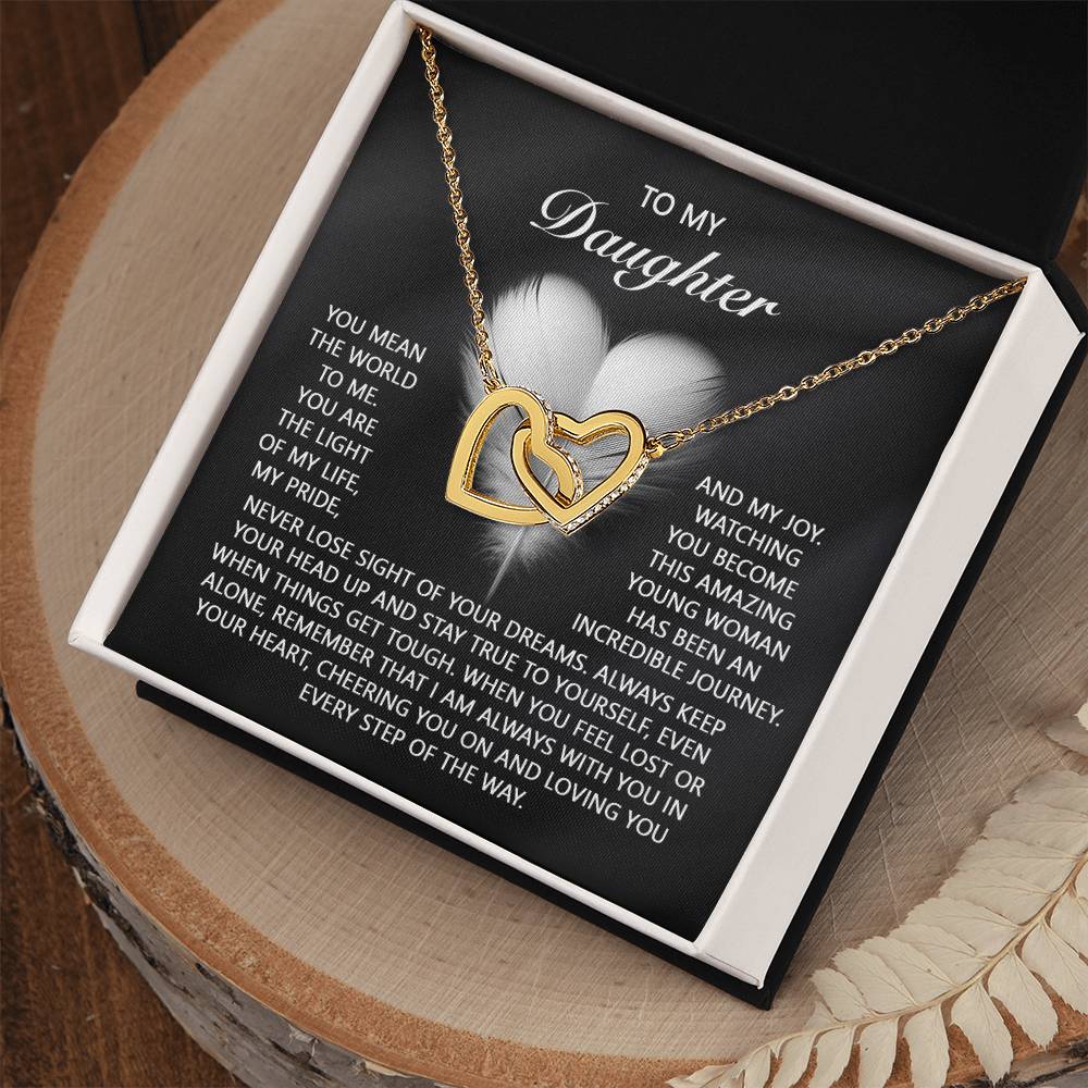 The Daughter-In Your Heart - Interlocking Hearts Necklace features a heart-shaped pendant adorned with cubic zirconia crystals and comes in an open gift box with a heartfelt message to a daughter.