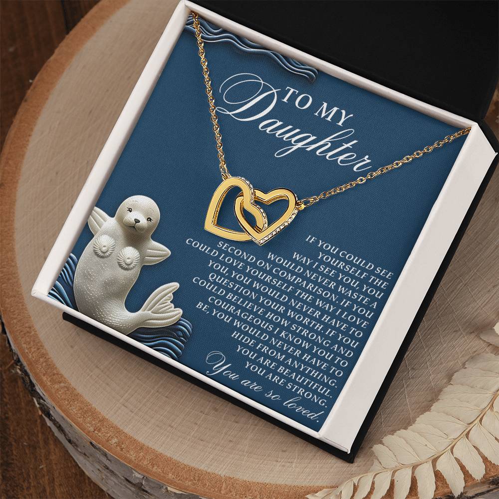 The "Daughter-So Loved" gift box includes a heartfelt note saying "To My Daughter," an Interlocking Hearts Necklace adorned with cubic zirconia crystals, and features a wave-decorated seal in the corner.