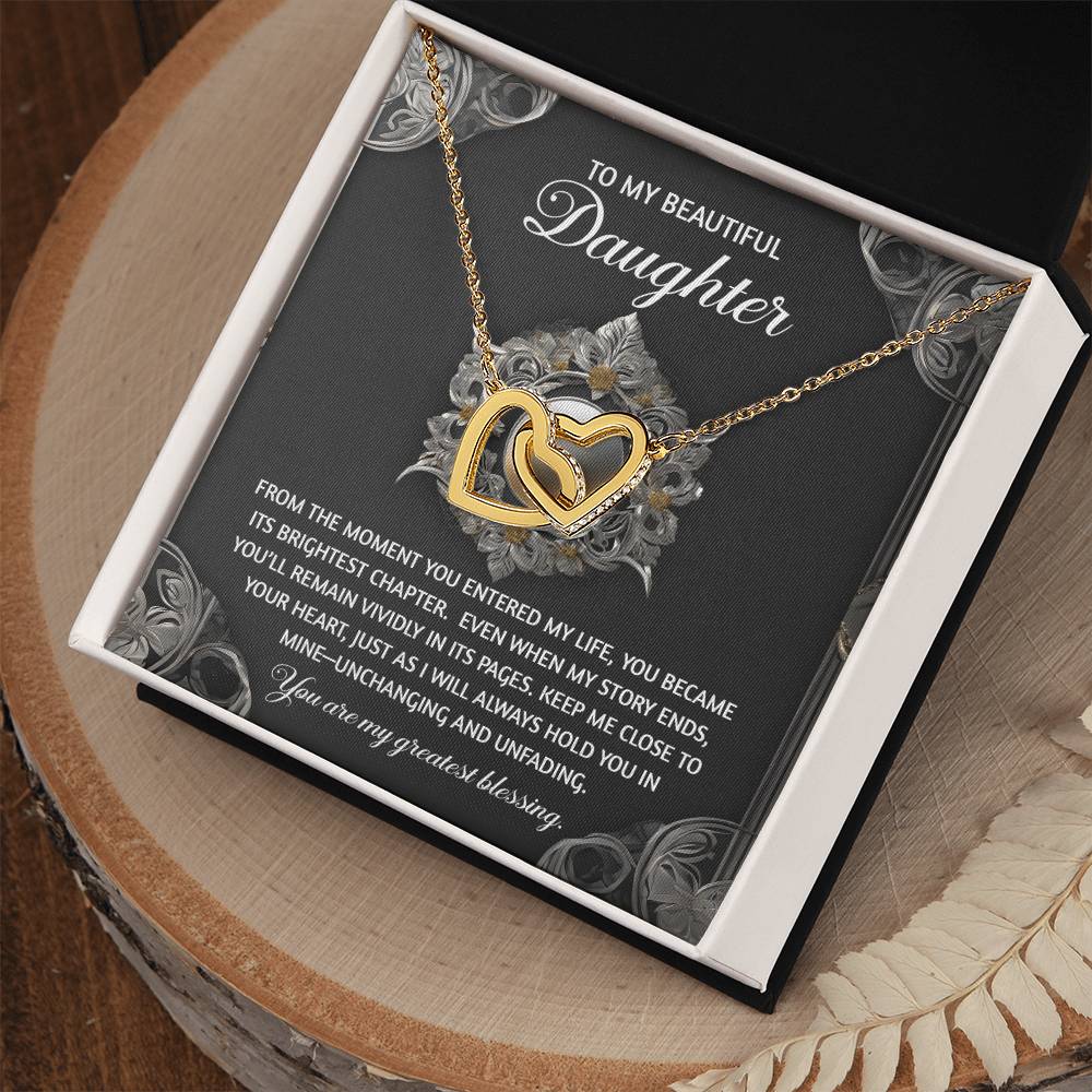 The Daughter-Greatest Blessing - Interlocking Hearts Necklace rests elegantly in its open box, adorned with sparkling cubic zirconia crystals. Its rose gold finish adds sophistication, complementing the heartfelt message inside for a beloved daughter.