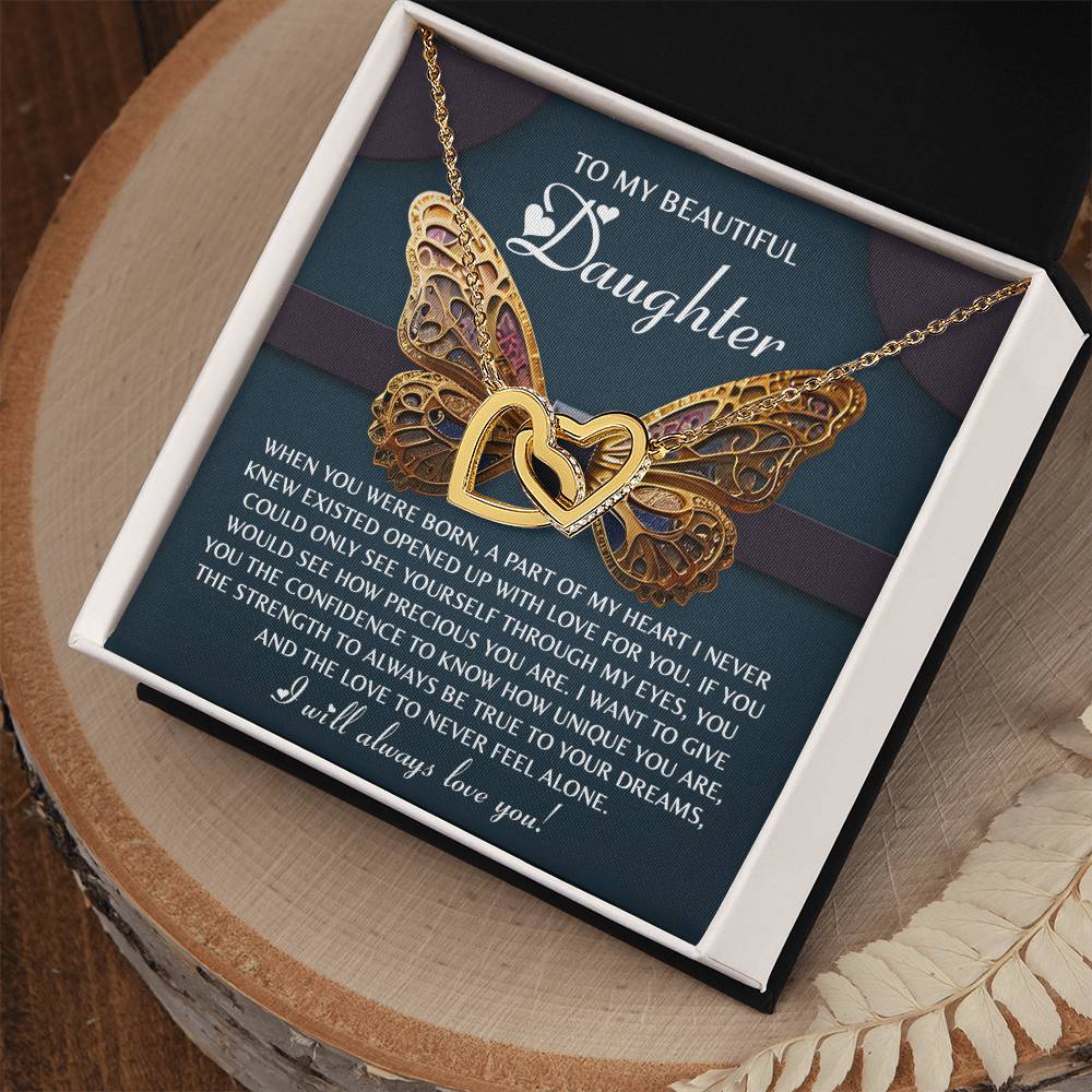 The Daughter-Never Feel Alone - Interlocking Hearts Necklace, featuring cubic zirconia and a rose gold finish, elegantly rests in its jewelry box. A heartfelt message for a daughter accompanies it, expressing love and support as the box sits on a wooden surface.