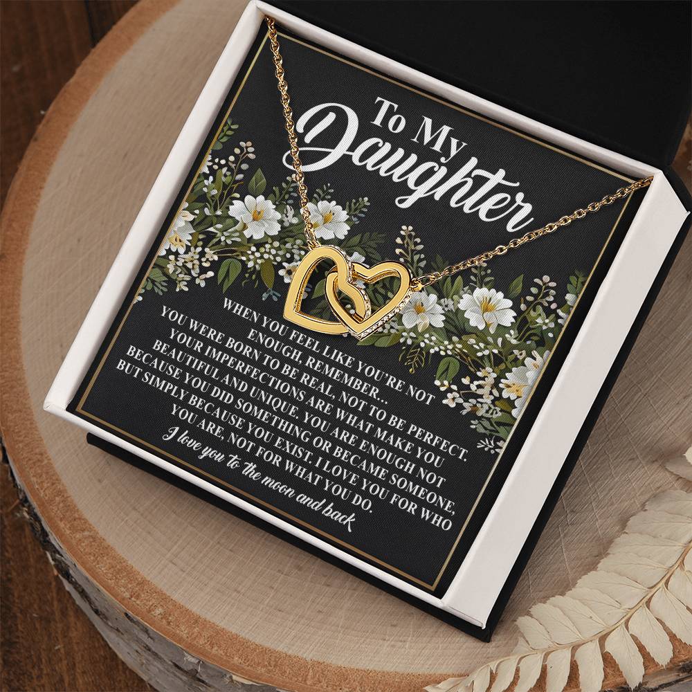 The Daughter-What You Do Interlocking Hearts Necklace with a rose gold finish is elegantly displayed on a card reading "To My Daughter," featuring a touching message about being loved and enough despite imperfections, all set against a floral background.
