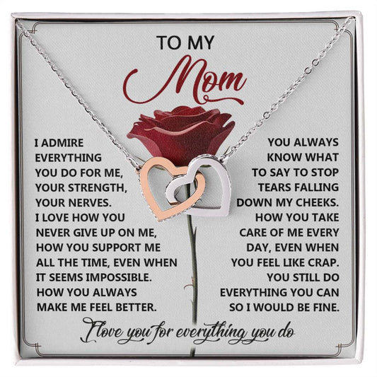 The Mom-Be Fine - Interlocking Hearts Necklace set includes a gift box with a touching message for mothers' support, featuring interlocking pendants—one gold and one silver—adorned with cubic zirconia crystals.