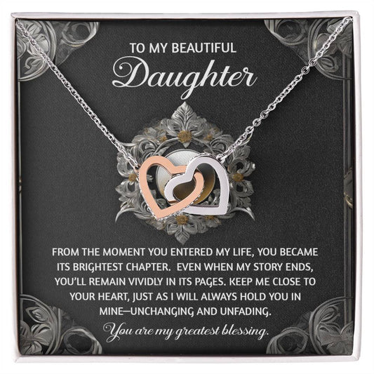 The Daughter-Greatest Blessing - Interlocking Hearts Necklace combines silver and gold on a decorative card, adorned with cubic zirconia crystals and a heartfelt message for a daughter, conveying love and gratitude.