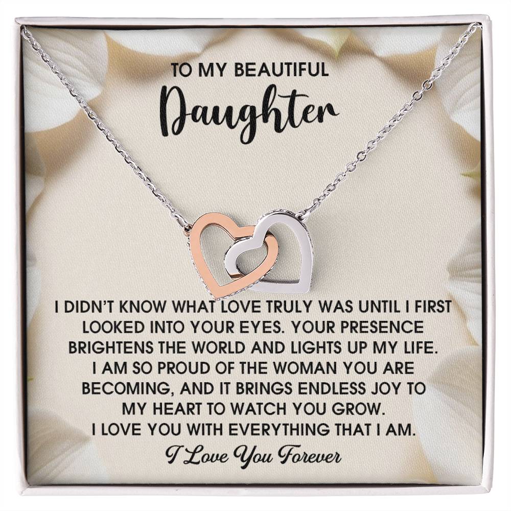 The Daughter-Into Your Eyes - Interlocking Hearts Necklace features a rose gold finish with shimmering cubic zirconia crystals and comes with a message card expressing love and pride for a daughter.