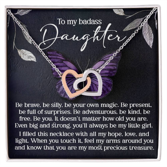 The Daughter-Big And Strong - Interlocking Hearts Necklace, finished in rose gold, features heart pendants adorned with cubic zirconia crystals. Set against a backdrop of a purple butterfly, it reads "To my badass daughter" and conveys love, strength, and cherished memories.