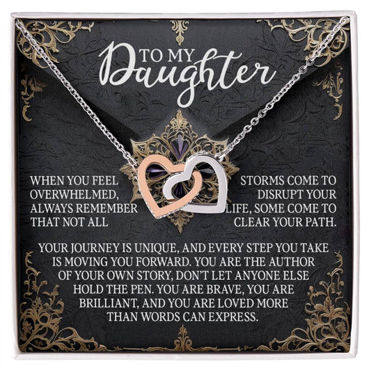 The Daughter-The Pen - Interlocking Hearts Necklace is showcased with cubic zirconia crystals against a decorative background. It features the text "To My Daughter" along with a supportive message encouraging her to embrace uniqueness, bravery, independence, and resilience.