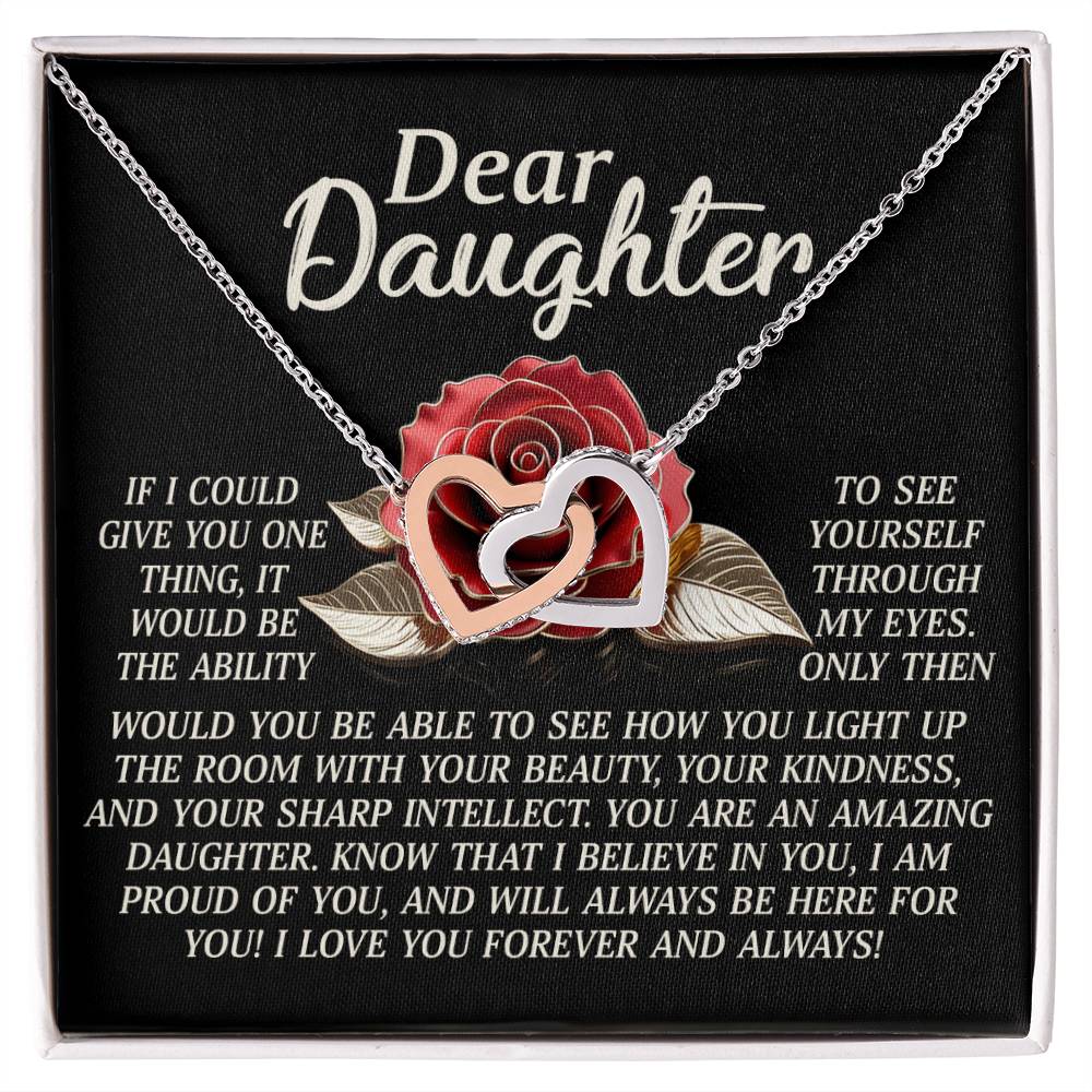 The Daughter-Your Light Interlocking Hearts Necklace, with a rose gold finish, sparkles against a black backdrop with roses. It reads: "Dear Daughter, if I could give you anything, it would be the ability to see yourself through my eyes... You are amazing... I love you forever and always!.