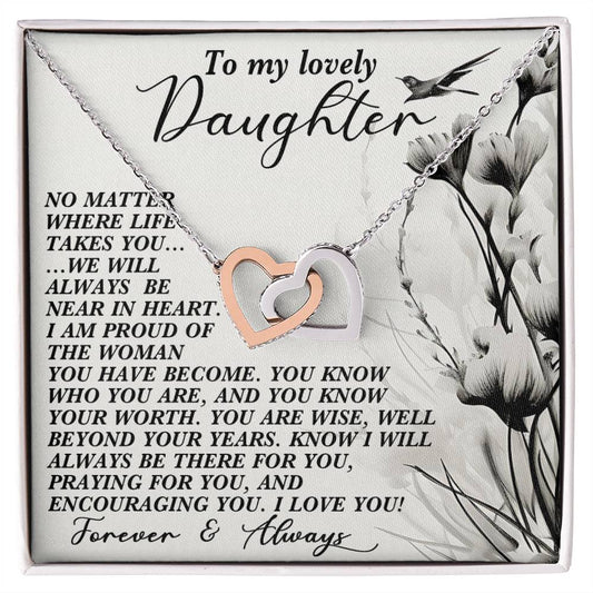 The Daughter-Heart Near Interlocking Hearts Necklace showcases silver and rose gold heart pendants with sparkling cubic zirconia crystals. It comes on a floral-illustrated card conveying a heartfelt message of love and encouragement to a cherished daughter.