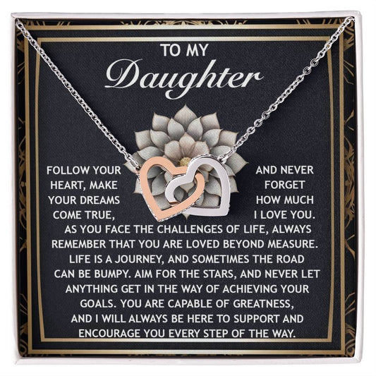 The Daughter-In The Way - Interlocking Hearts Necklace, featuring cubic zirconia crystals with a rose gold finish, is presented on a card bearing an inspirational message from a parent to their daughter.