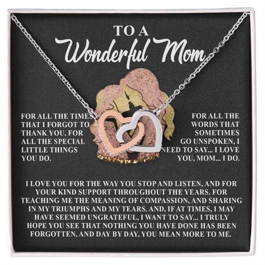 The open box showcases the "Mom-More To Me - Interlocking Hearts Necklace," a silver heart-shaped design with cubic zirconia crystals and the inscription "To a Wonderful Mom." The backdrop displays a touching message of gratitude and love for a mother's unwavering support and understanding.