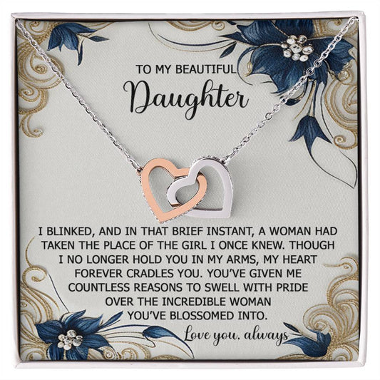 The Daughter-In My Arms - Interlocking Hearts Necklace, featuring cubic zirconia heart pendants and a keepsake card for a daughter, is elegantly finished in rose gold to enhance its sentimental message and floral designs.