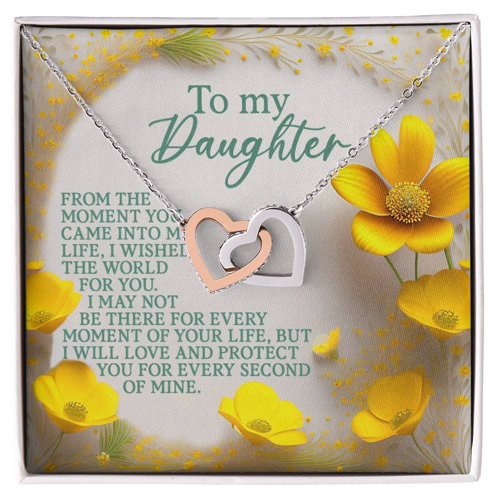 The Daughter-Every Moment Interlocking Hearts Necklace, with a rose gold finish and cubic zirconia crystal-adorned heart pendants, rests on a floral card reading: "To my Daughter; From the moment you came into my life, I wished the world for you. I may not be there for every moment, but I love and protect you.