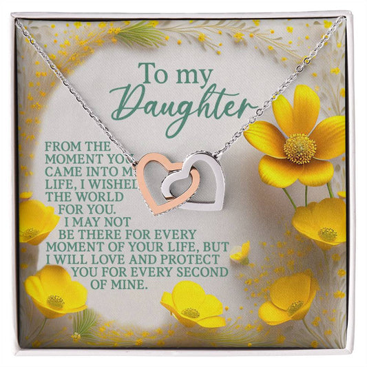The Daughter-Every Moment Interlocking Hearts Necklace, with a rose gold finish and cubic zirconia crystal-adorned heart pendants, rests on a floral card reading: "To my Daughter; From the moment you came into my life, I wished the world for you. I may not be there for every moment, but I love and protect you.