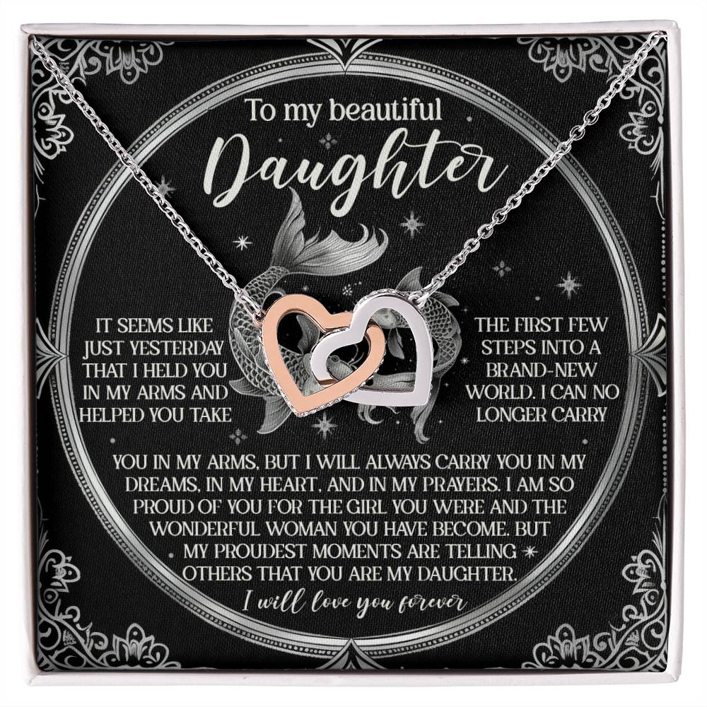 The Daughter-In My Prayers - Interlocking Hearts Necklace features interlocking heart charms with cubic zirconia crystals on a box with a loving message for a daughter, expressing love and cherished memories, adorned with mermaid decorations and ornate borders.