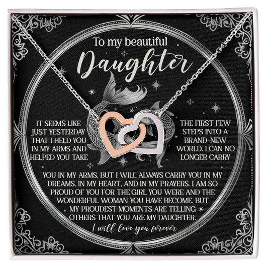 The Daughter-In My Prayers - Interlocking Hearts Necklace features interlocking heart charms with cubic zirconia crystals on a box with a loving message for a daughter, expressing love and cherished memories, adorned with mermaid decorations and ornate borders.