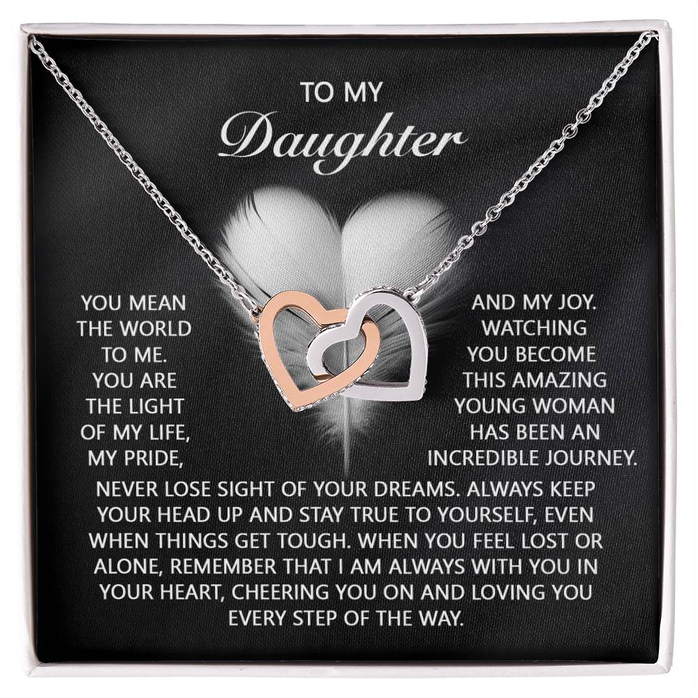 The "Daughter-In Your Heart - Interlocking Hearts Necklace" features rose gold-finished pendants adorned with shimmering cubic zirconia crystals, beautifully complementing the heartfelt message from a parent to their daughter.
