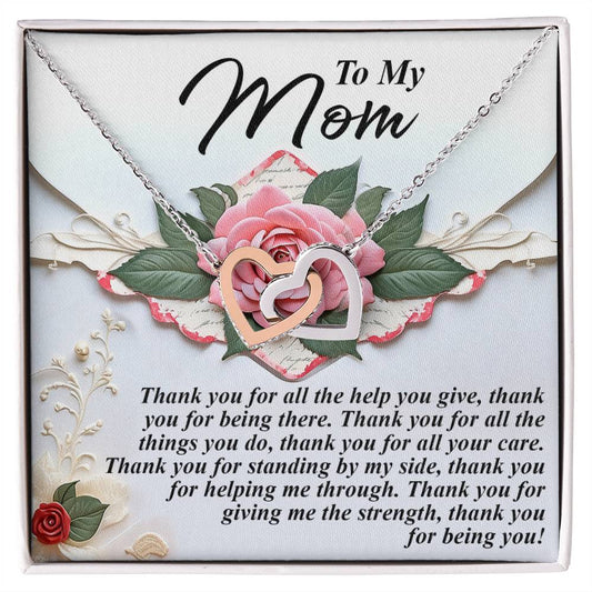 The Mom-Being You - Interlocking Hearts Necklace features silver pendants embellished with cubic zirconia and rests on a card adorned with a pink rose, expressing heartfelt gratitude to a mother.