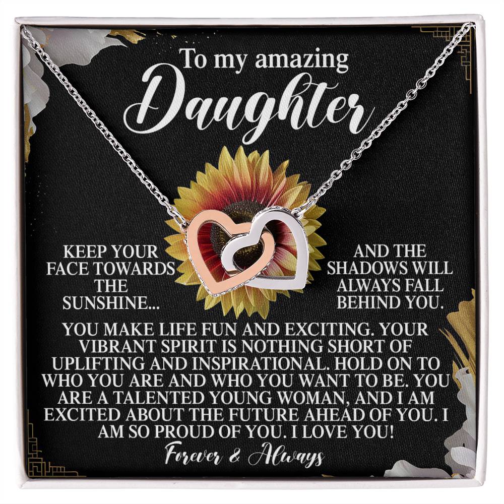 The Daughter-Vibrant Spirit - Interlocking Hearts Necklace sparkles with cubic zirconia crystals against a floral backdrop. A heartfelt message above conveys pride and love, making this elegant gift for her a perfect blend of sophistication and warmth.