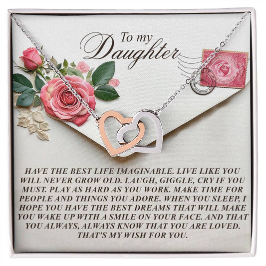The Daughter-My Wish - Interlocking Hearts Necklace features a rose gold finish with cubic zirconia crystals. It comes on a gift card with pink and white roses, reading "To my Daughter," conveying love and hopes for happiness and dreams.
