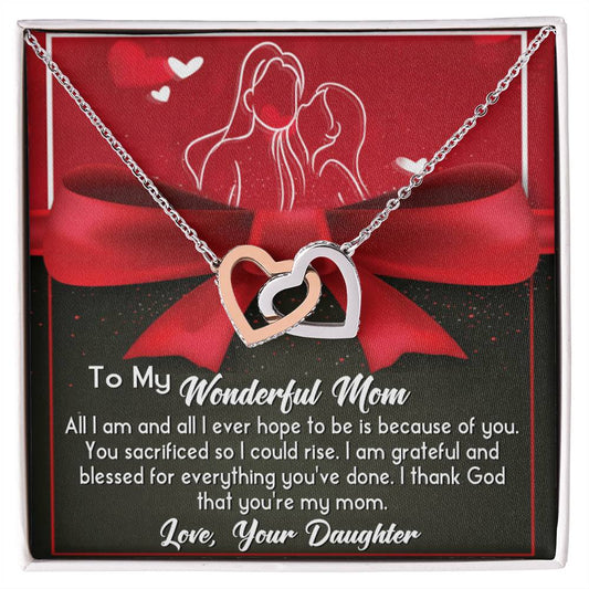 The "To Mom, Because Of You - Interlocking Hearts Necklace," elegantly adorned with cubic zirconia crystals, rests on a card expressing heartfelt gratitude from a daughter to her mother.