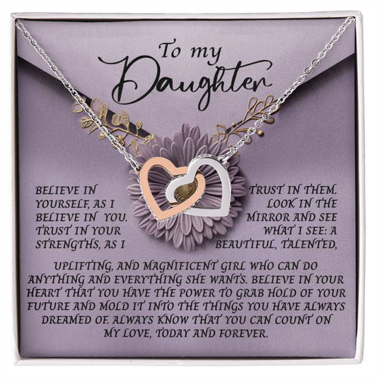 The Daughter-Magnificent Girl Interlocking Hearts Necklace showcases delicate pendants with cubic zirconia crystals, presented in a gift box. The lid reads "To my Daughter" with an inspiring message about self-belief and embracing her unique strengths.