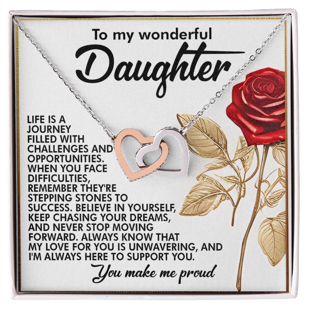 The Daughter-Journey Challenges - Interlocking Hearts Necklace features intertwined rose gold and silver hearts adorned with cubic zirconia crystals. It comes with a card encouraging a daughter to persevere and believe in her dreams, ending lovingly with "You make me proud," alongside a red rose illustration.