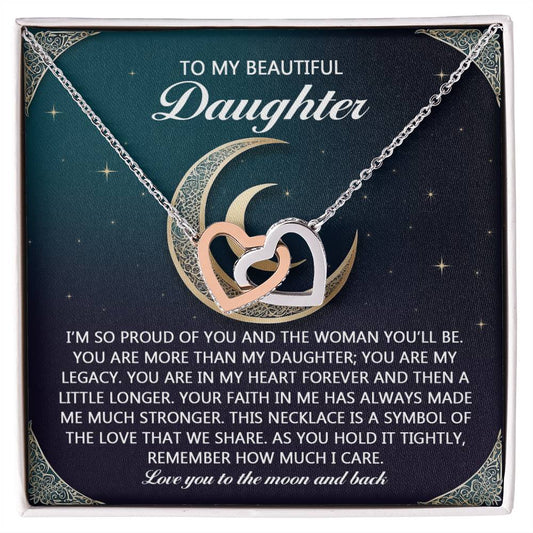 The Daughter-Hold It Tightly Interlocking Hearts Necklace, featuring gold and silver heart pendants on a card with a crescent moon, is crafted from polished surgical steel and carries a heartfelt message expressing pride, love, and cherished memories to a daughter.