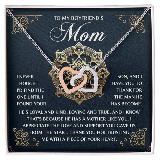 The Mom-Thankful Heart - Interlocking Hearts Necklace shines with an 18k yellow gold finish, nestled in a jewelry box featuring a golden design. The lid bears a heartfelt message to a boyfriend’s mom, expressing gratitude for her son’s qualities and unwavering support.