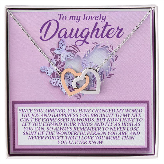 The Daughter-Expand Wings Interlocking Hearts Necklace, with a rose gold finish, is displayed on a "To my lovely Daughter" card featuring purple accents and an emotional note on love and growth.