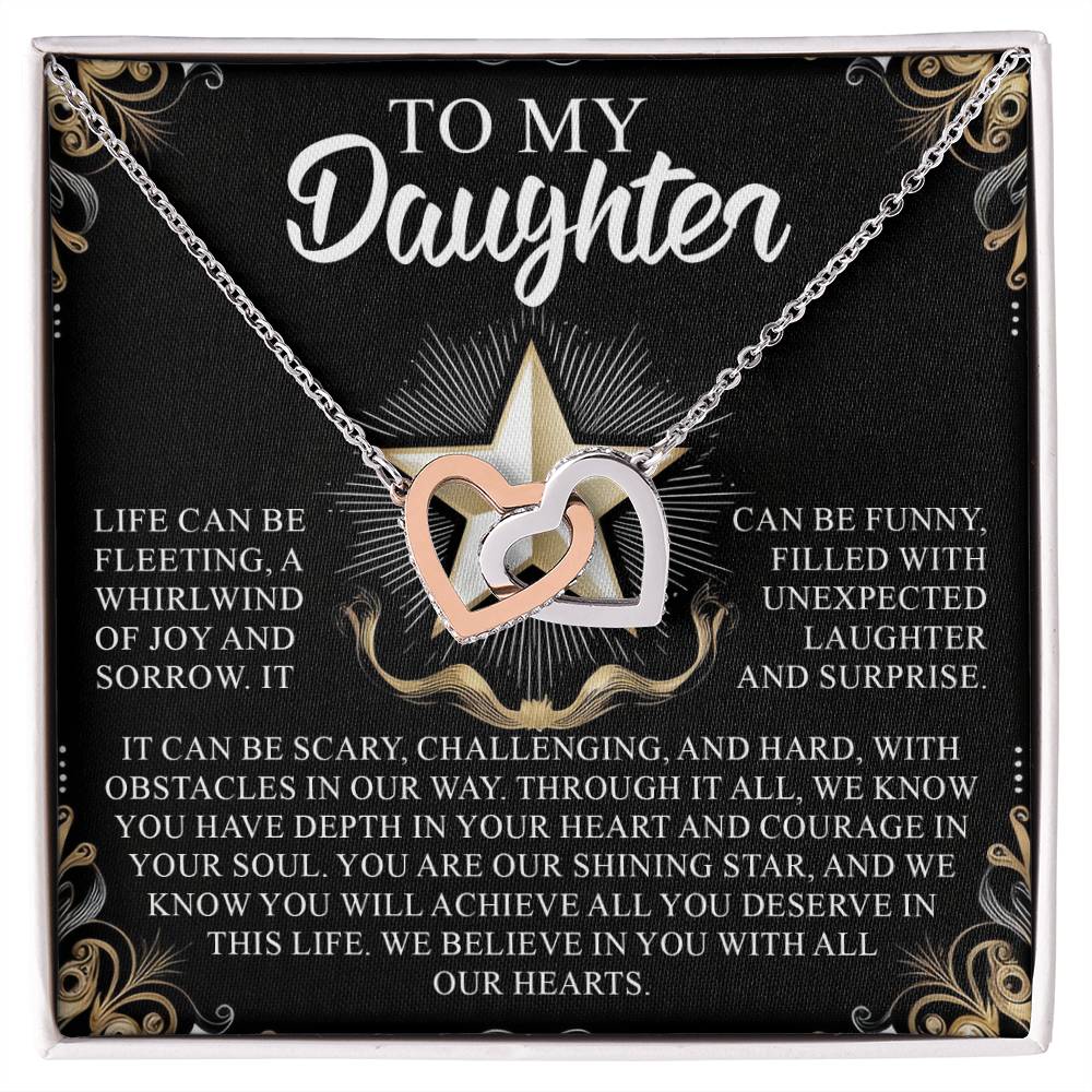 The Daughter-Shining Star gift box includes an Interlocking Hearts necklace with cubic zirconia crystals. It features heartfelt messages of love, joy, courage, and support for a daughter amidst life's challenges, beautifully framed with decorative gold patterns.
