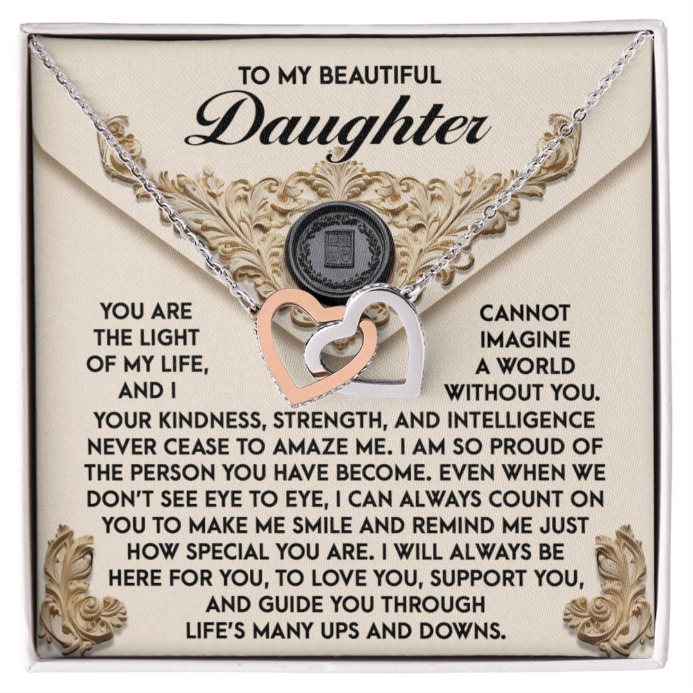 The Daughter-Amaze Me - Interlocking Hearts Necklace, embellished with cubic zirconia crystals and a rose gold finish, elegantly rests on a decorative card featuring a heartfelt message for your daughter.