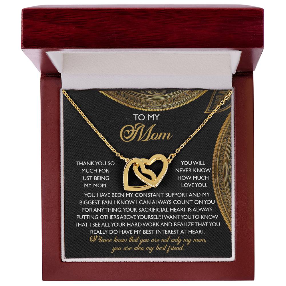 A Mom-Best Friend - Interlocking Hearts Necklace with a rose gold finish lies in an open red jewelry box. Decorated with cubic zirconia crystals, the lid carries a heartfelt message thanking a mother for her unwavering support and care.