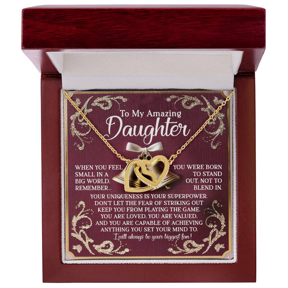An open red jewelry box displays the Daughter-Stand Out - Interlocking Hearts necklace with a rose gold finish, featuring sparkling cubic zirconia crystals. The inside lid reads: "To My Amazing Daughter" and includes a heartfelt message about individuality, love, and support.